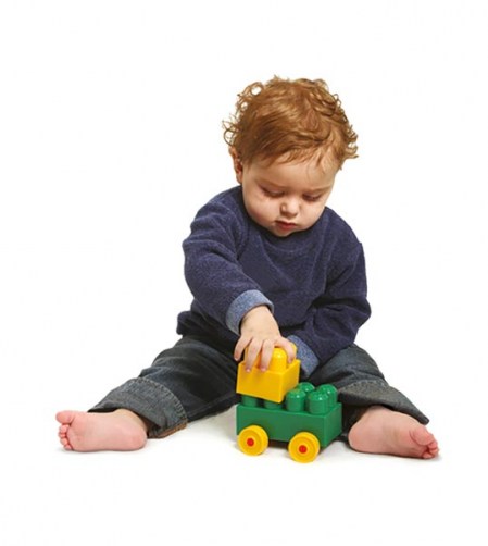 کودک یک ساله در حال بازی با آجره
